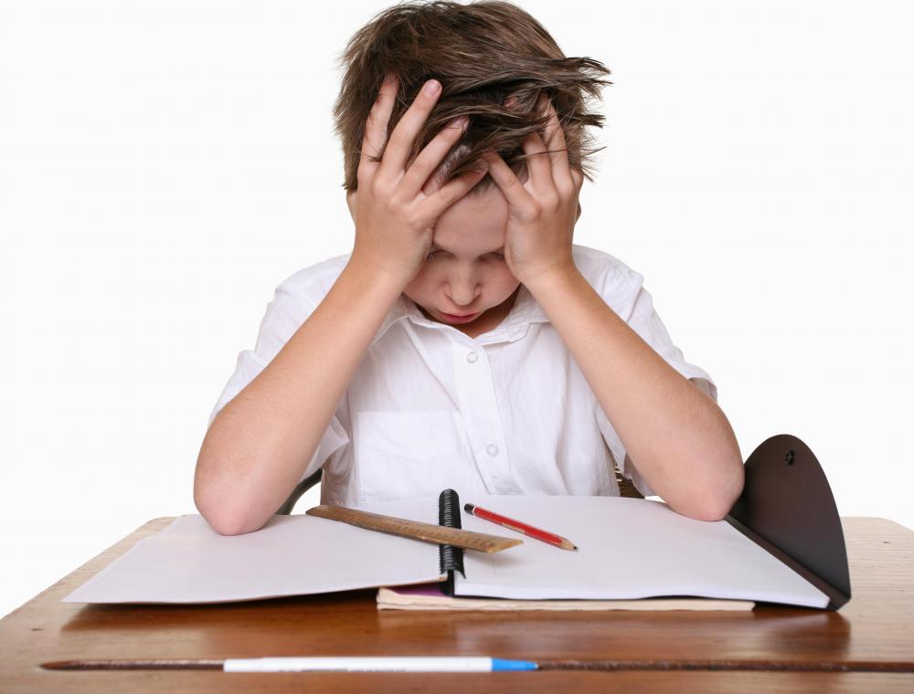 child-in-white-frustrated-while-looking-at-paper-on-desk